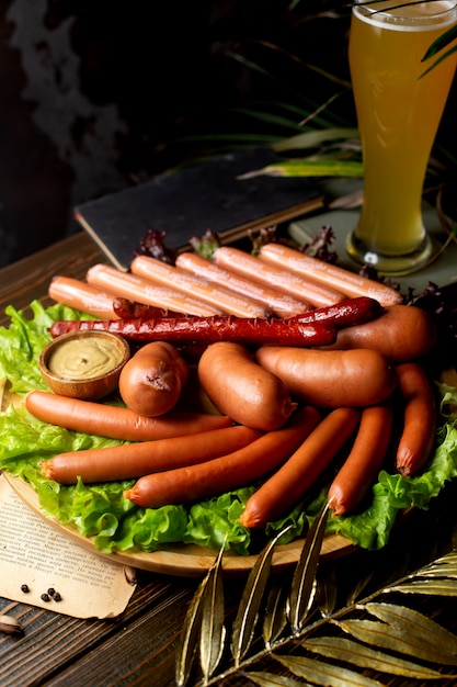 Free photo sausages served with mustard and glass of beer