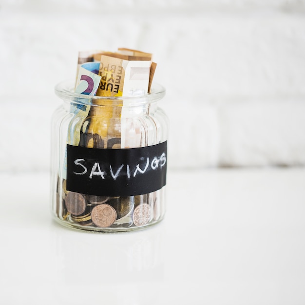 Free Photo savings glass jar with euro notes and coins on white backdrop