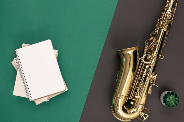 Free Photo saxophone on a green background and notepad top view