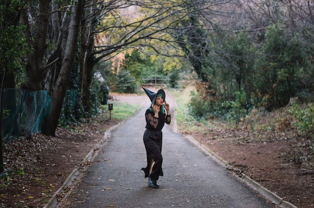 Free Photo scared witch walking along forest road