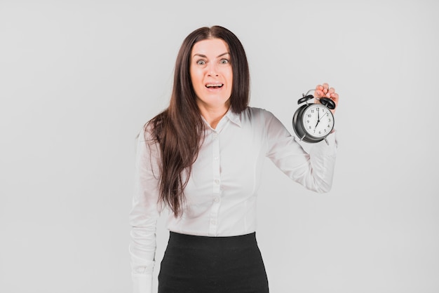 Scared woman alarm clock and looking at camera 