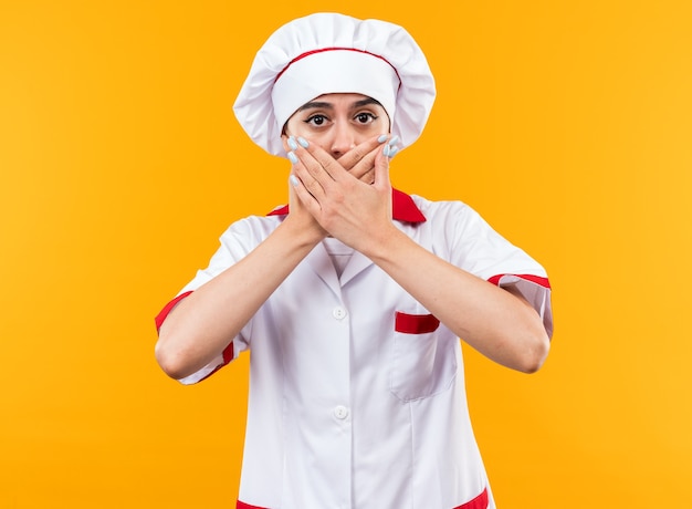 Scared young beautiful girl in chef uniform covered mouth with hnads 