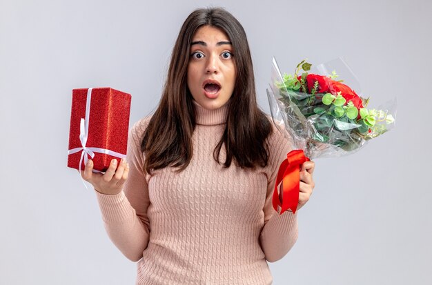 Scared young girl on valentines day holding gift box with bouquet isolated on white background