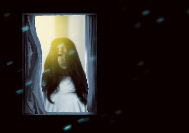 Free Photo scary ghost woman standing on the window. halloween concept