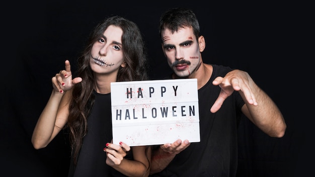 Free photo scary male and female with signboard