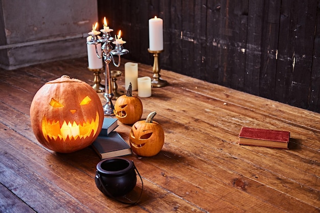 Scary pumpkins and candles on a wooden floor in an old house. Halloween concept.