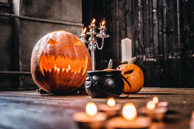 Free Photo scary pumpkins and candles on a wooden floor in an old house. halloween concept.