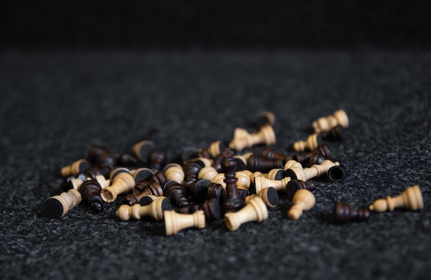 Scattered chess pieces on a blurred black background