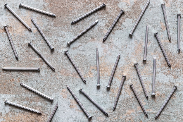 Free Photo scattered nails on grunge wooden desk