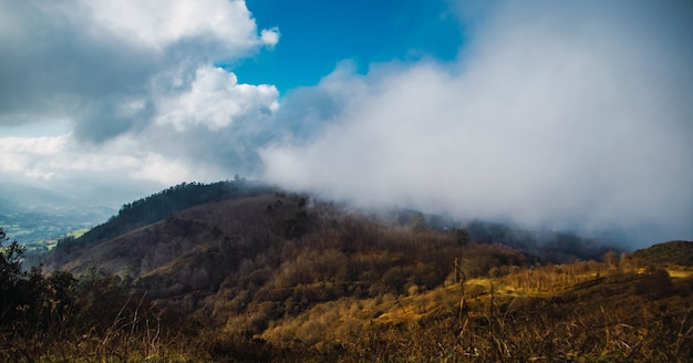 Scenery of smoke over the mountain under the cloudy sky