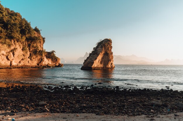 Scenery of sunset with a beautiful rock formation in the beach of Rio De Janeiro, Brazil