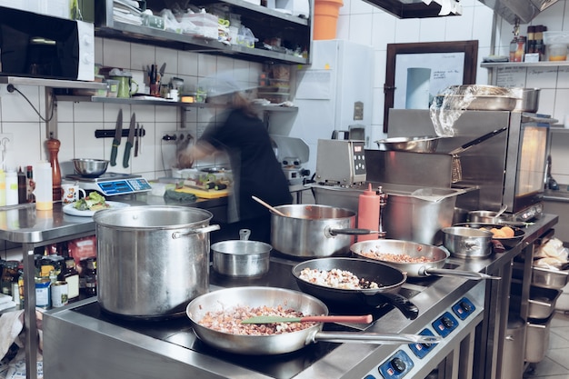 Behind the scenes of brands. The chef cooking in a professional kitchen of a restaurant meal for client or delivery.