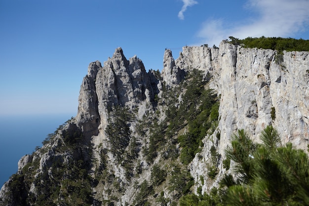 Scenic view of amazing Mount Ai-Petri against blue sky and the Black sea background. Mountains, hiking, adventure, traveling, tourist attraction, landscape and altitude concept. Crimea, Russia.