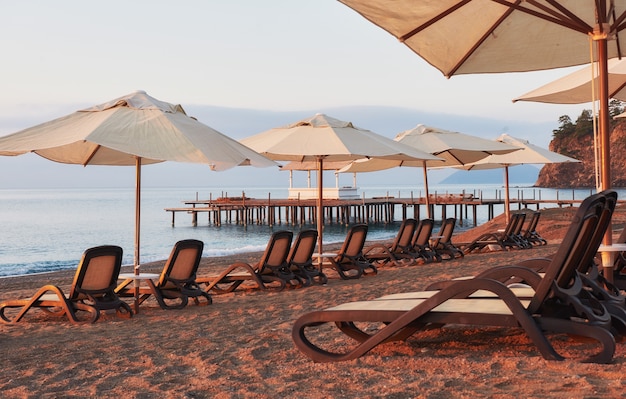 Scenic view of private sandy beach on the beach with sun beds against the sea and mountains. Amara Dolce Vita Luxury Hotel. Resort. Tekirova-Kemer. Turkey