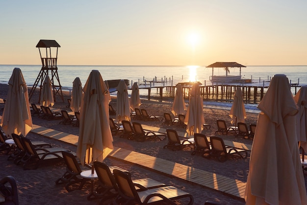 Free Photo scenic view of private sandy beach with sun beds and parasokamy the sea and mountains. resort.