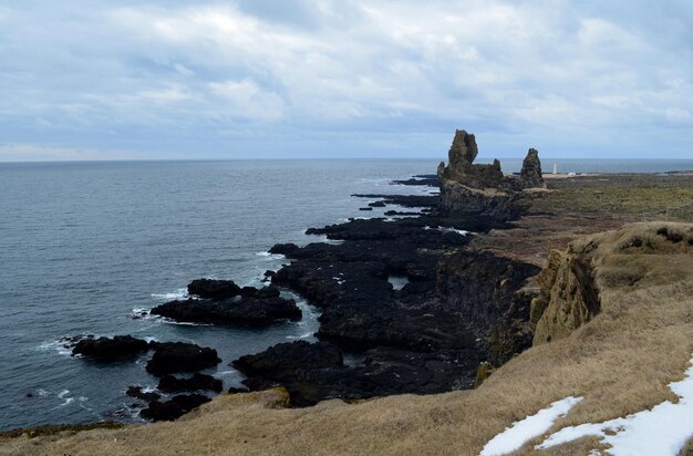 Scenic views of Londrangar lava rock formation along the coast of Iceland.