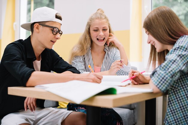 School boy and girls at desk with books