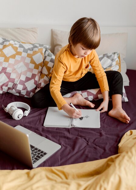 School boy sitting in bed and learn