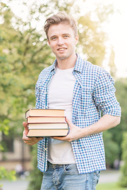 School boy with book in park