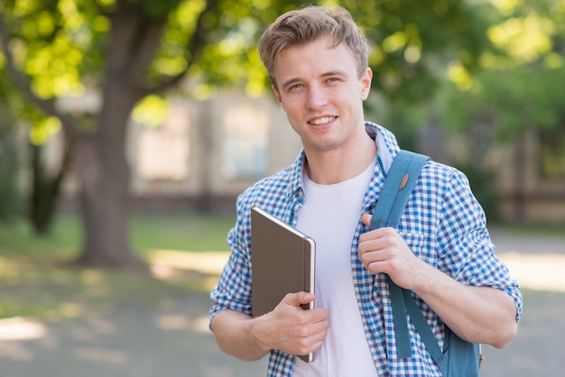 School boy with book in park