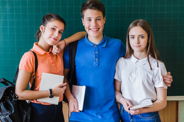 School friends posing in front of the blackboard