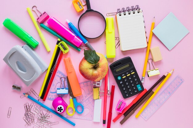 School supplies and apple laid in random way