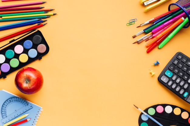 Free photo school supplies scattered on yellow table