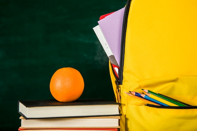 Free Photo schoolbag, pile of books and orange