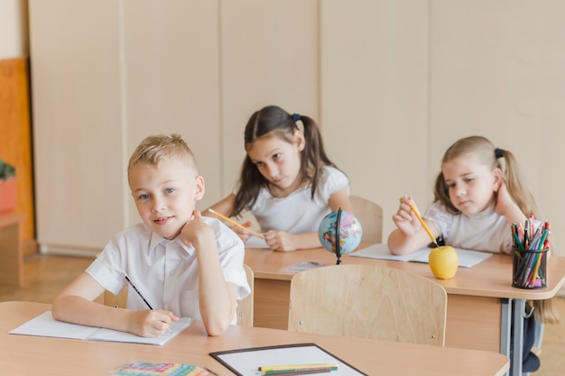 Free photo schoolboy looking at camera at classroom