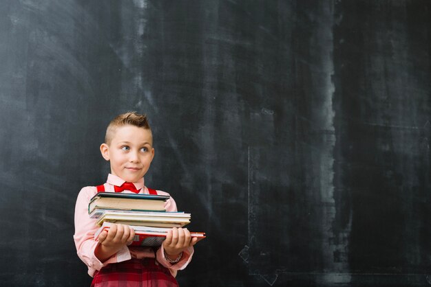 Schoolboy standing with books