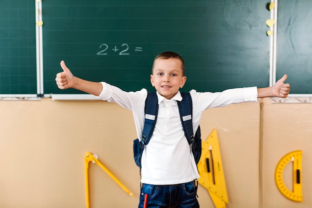 Schoolboy with thumbs up and hands apart