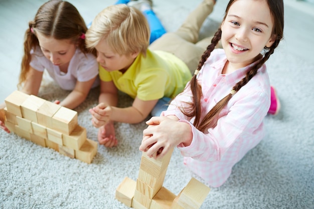 Schoolchildren playing with wooden blocks