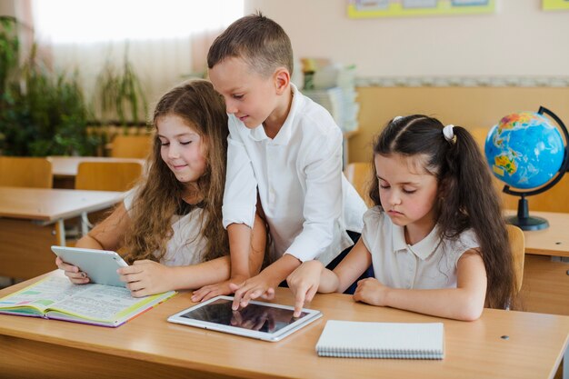 Schoolchildren using tablets in classroom