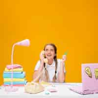 Free photo schoolgirl on desk with laptop in memphis style