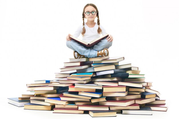 Schoolgirl reading on a pile of books