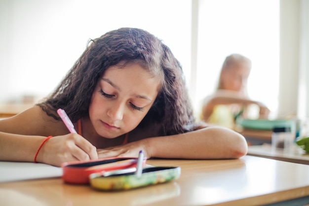 Schoolgirl sitting at desk writing