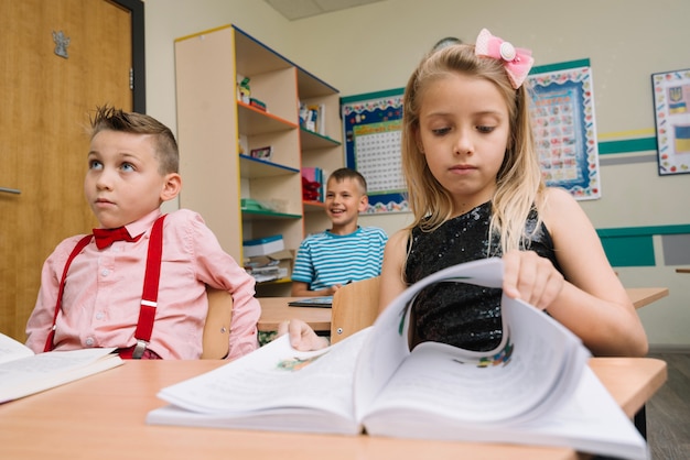 Free Photo schoolgirl sitting at lesson flipping pages