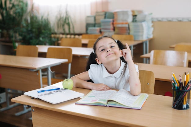 Schoolgirl sitting and pointing up