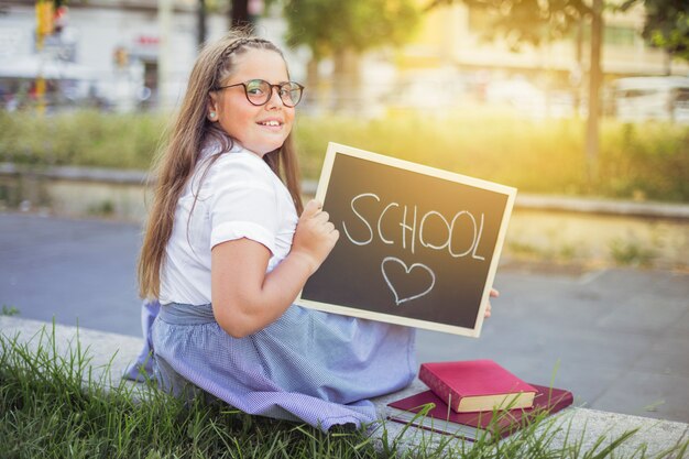 Schoolgirl in uniform with sign school love