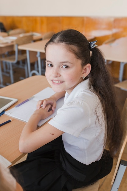 Free photo schoolgirl with ponytails looking at camera