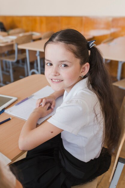 Schoolgirl with ponytails looking at camera