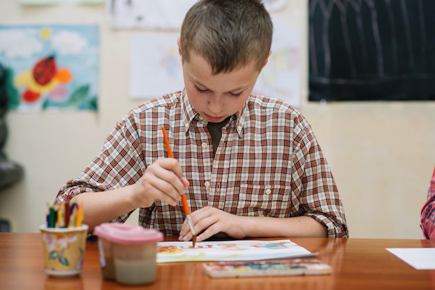 Free photo schoolkid drawing in class