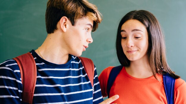 Schoolkid telling something to his friend