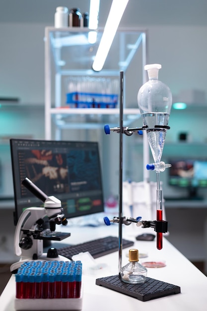 Free photo science laboratory equipment and test tube with blood for healthcare development. chemical dripping pipe with glass flask for analysis in biochemistry lab at clinic. professional instruments