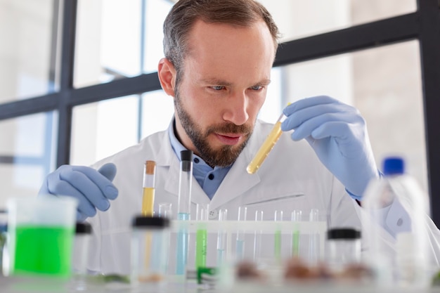 Scientist looking at tube medium shot