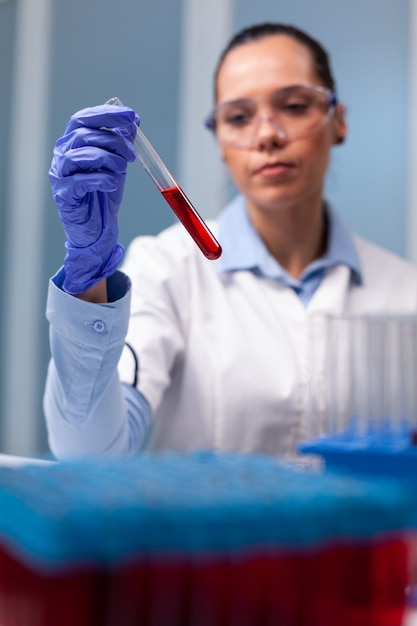 scientist researcher looking at blood test tube researching scientific biology expertise