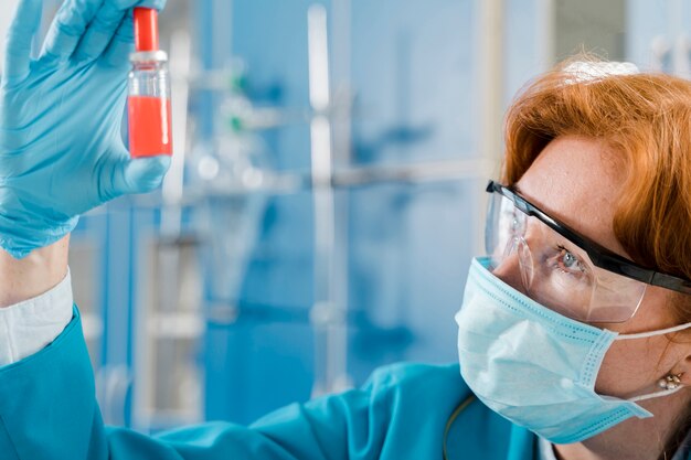 Scientist with mask looking at a sample