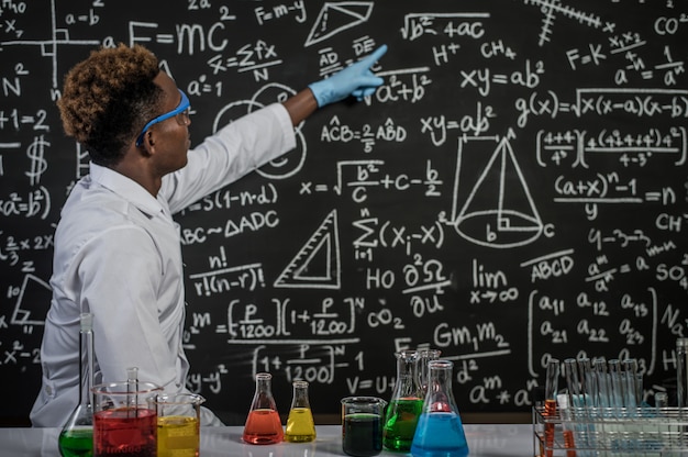 Free Photo scientists wear glasses and point to formulas on the blackboard in the laboratory