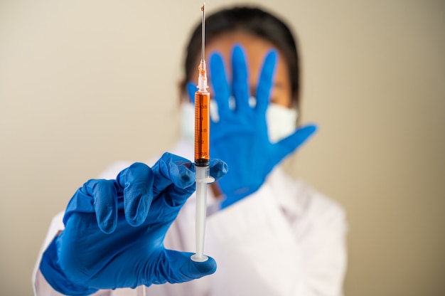 Scientists wearing masks and gloves Holding a syringe with a vaccine to prevent covid-19