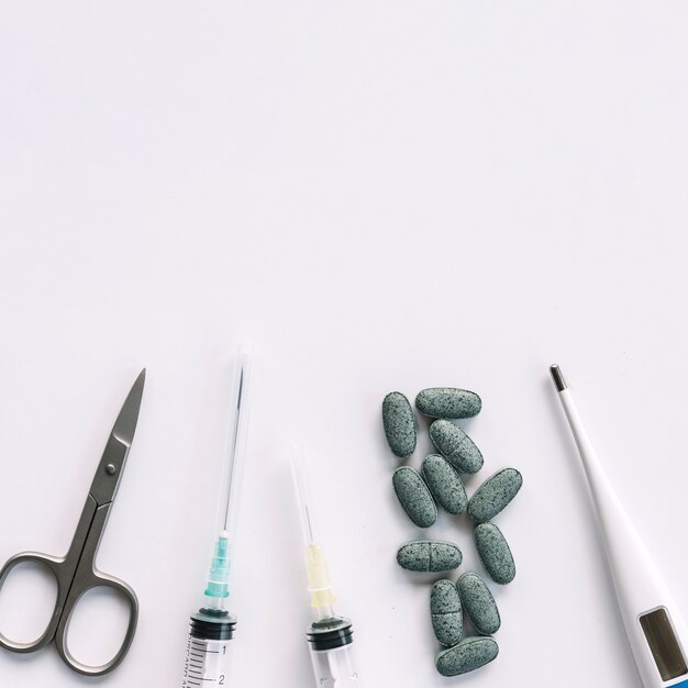 Scissor; syringe; tablets and thermometer isolated on white background